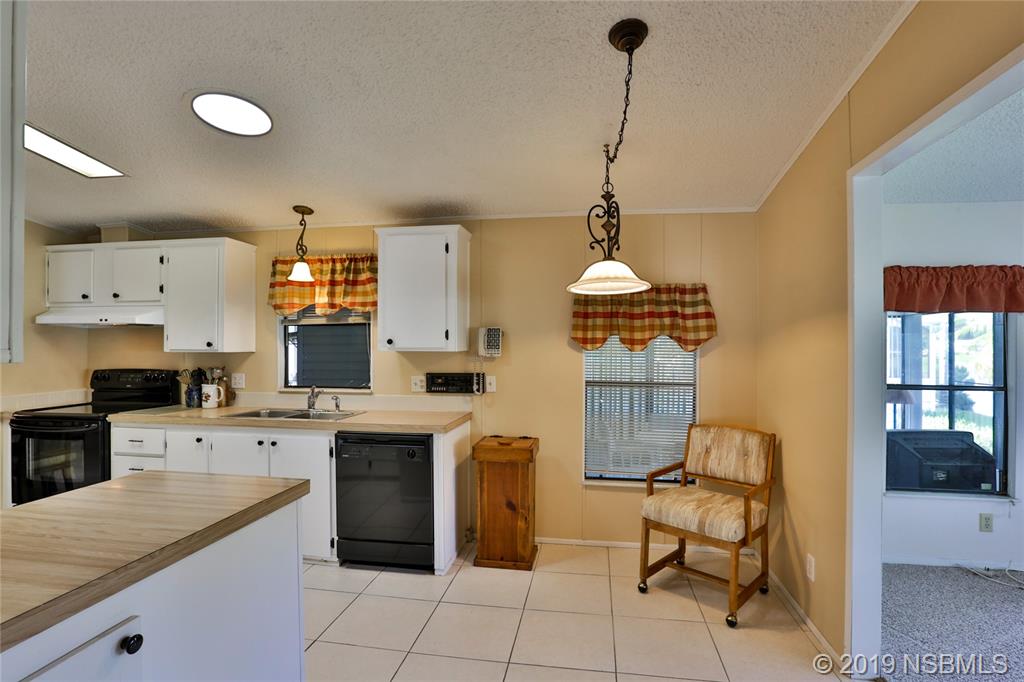 720 Navigators Way Edgewater, FL 32141 - Photo 14 of 35 a kitchen with a sink cabinets and window