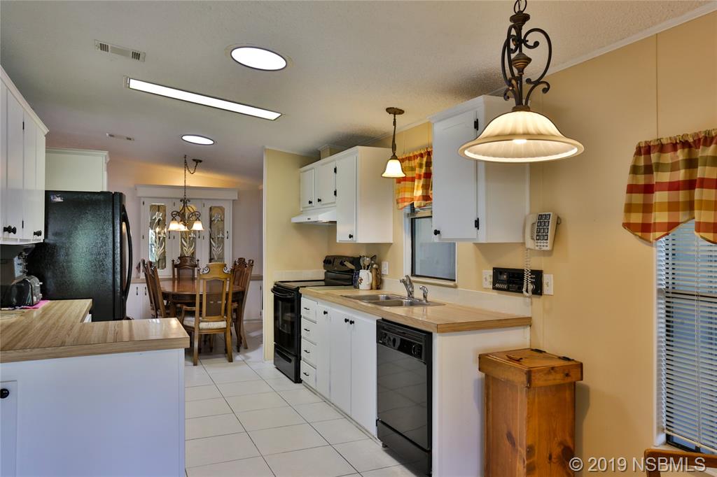 720 Navigators Way Edgewater, FL 32141 - Photo 15 of 35 a kitchen that has a lot of white cabinets and stainless steel appliances
