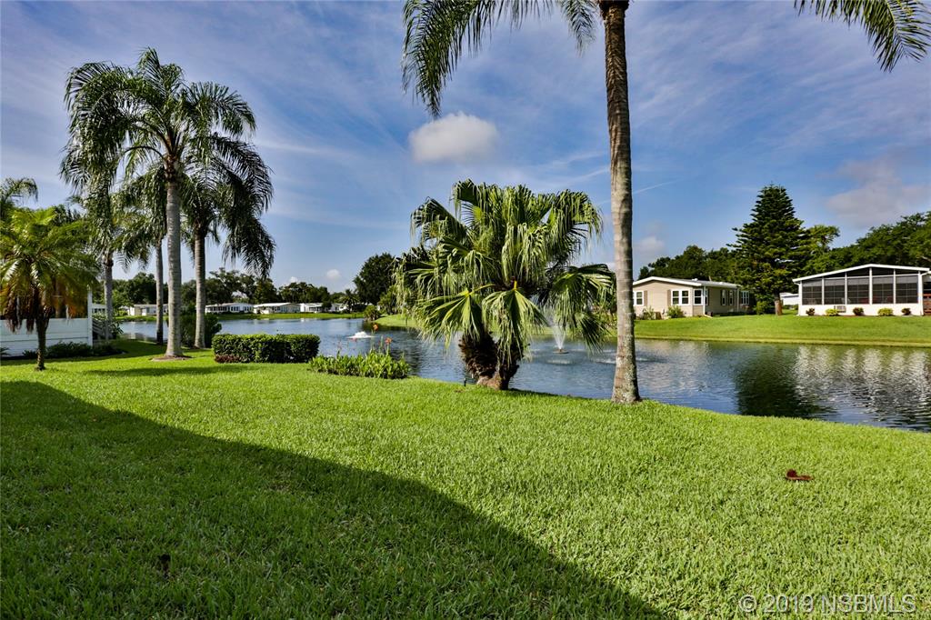 720 Navigators Way Edgewater, FL 32141 - Photo 35 of 35 a view of a lake with a building in the background