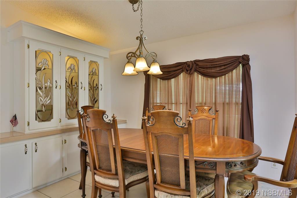 720 Navigators Way Edgewater, FL 32141 - Photo 10 of 35 a view of a dining room with furniture and a chandelier