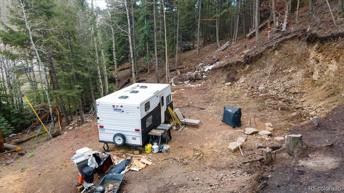 1521 Witter Gulch Road Evergreen, CO 80439 - Photo 16 of 20 a view of a backyard with chairs and iron fence