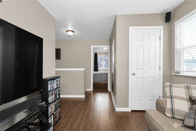 a view of a livingroom with wooden floor and furniture