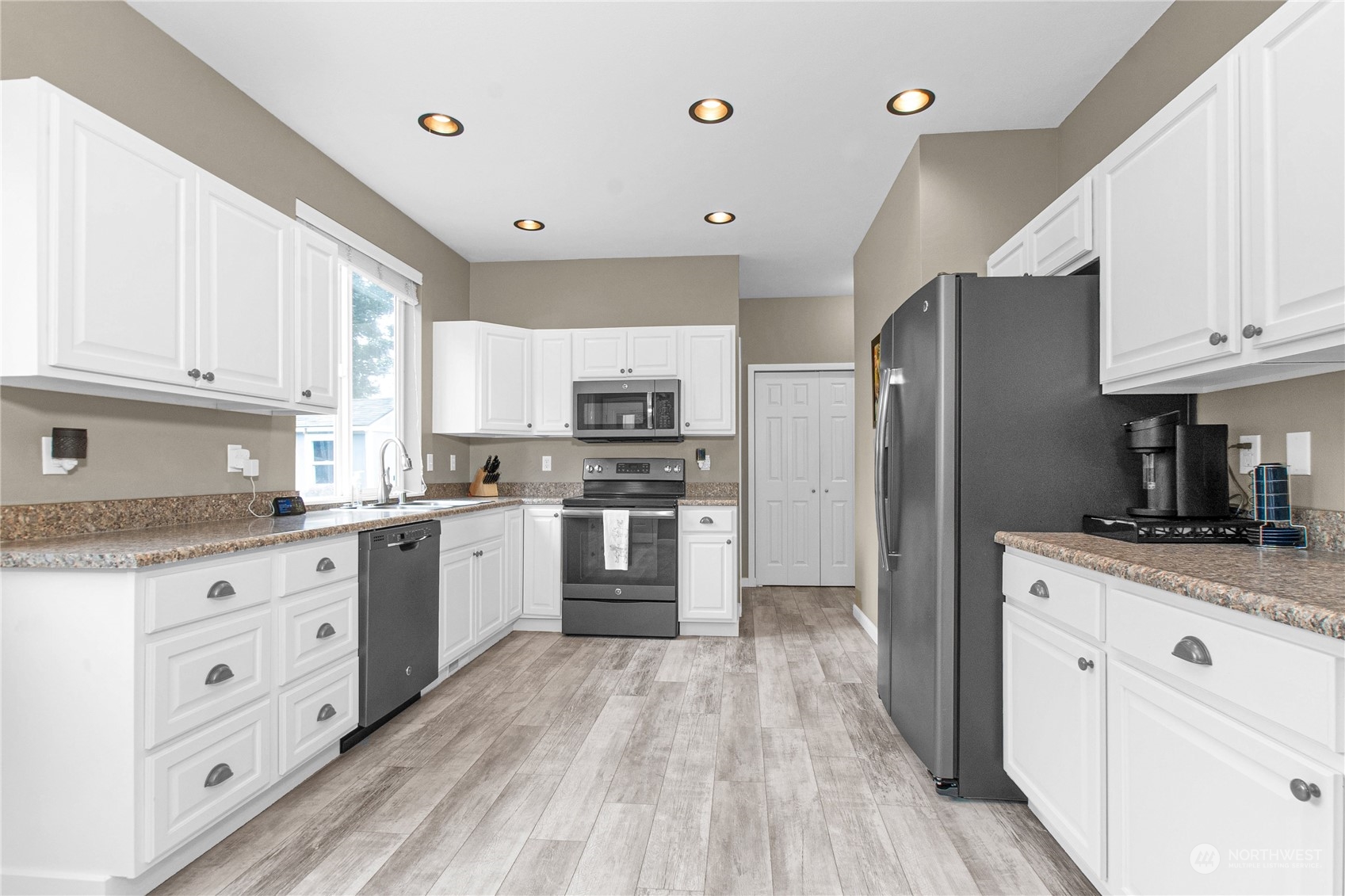 4619 211th Street East Spanaway, WA 98387 - Photo 2 of 36 a kitchen with granite countertop a refrigerator stove top oven and sink