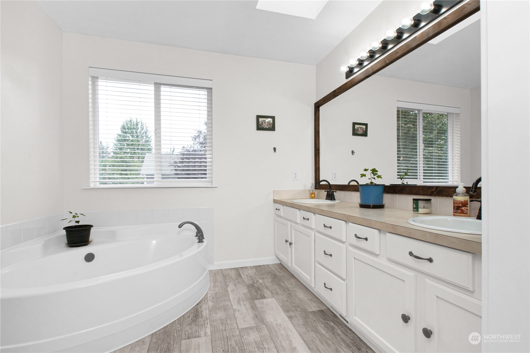 4619 211th Street East Spanaway, WA 98387 - Photo 24 of 36 a bathroom with a tub a sink a mirror and a window