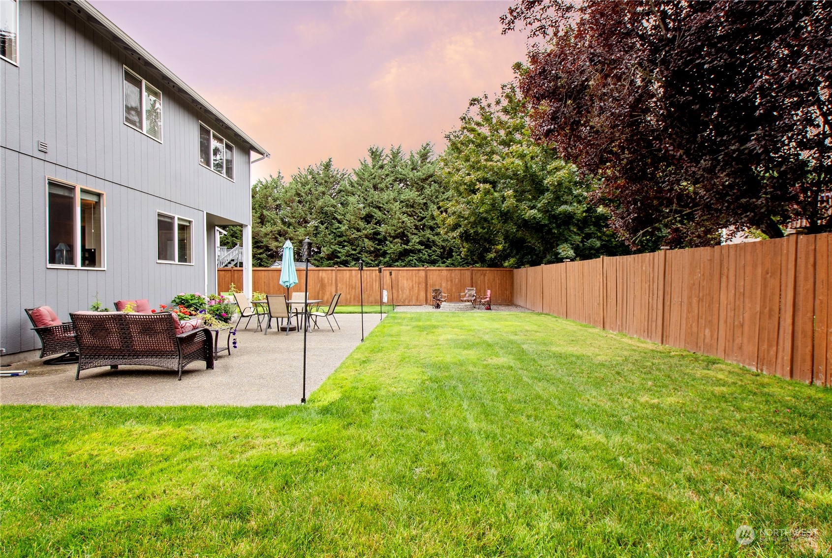 4619 211th Street East Spanaway, WA 98387 - Photo 31 of 36 a view of a backyard with table and chairs with wooden fence and plants