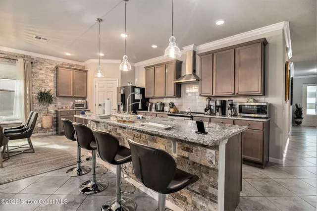 a kitchen with stainless steel appliances granite countertop a table chairs sink and cabinets
