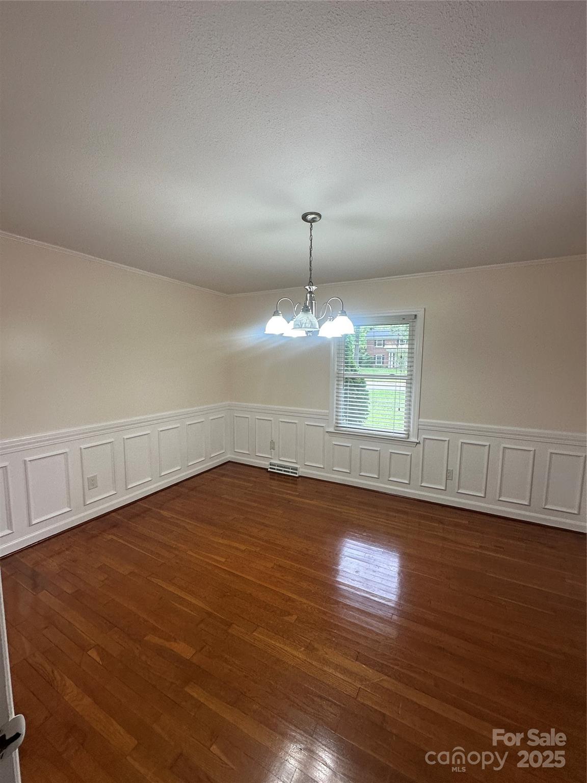 1115 Dumbarton Road Gastonia, NC 28054 - Photo 11 of 20 an empty room with wooden floor chandelier fan and windows