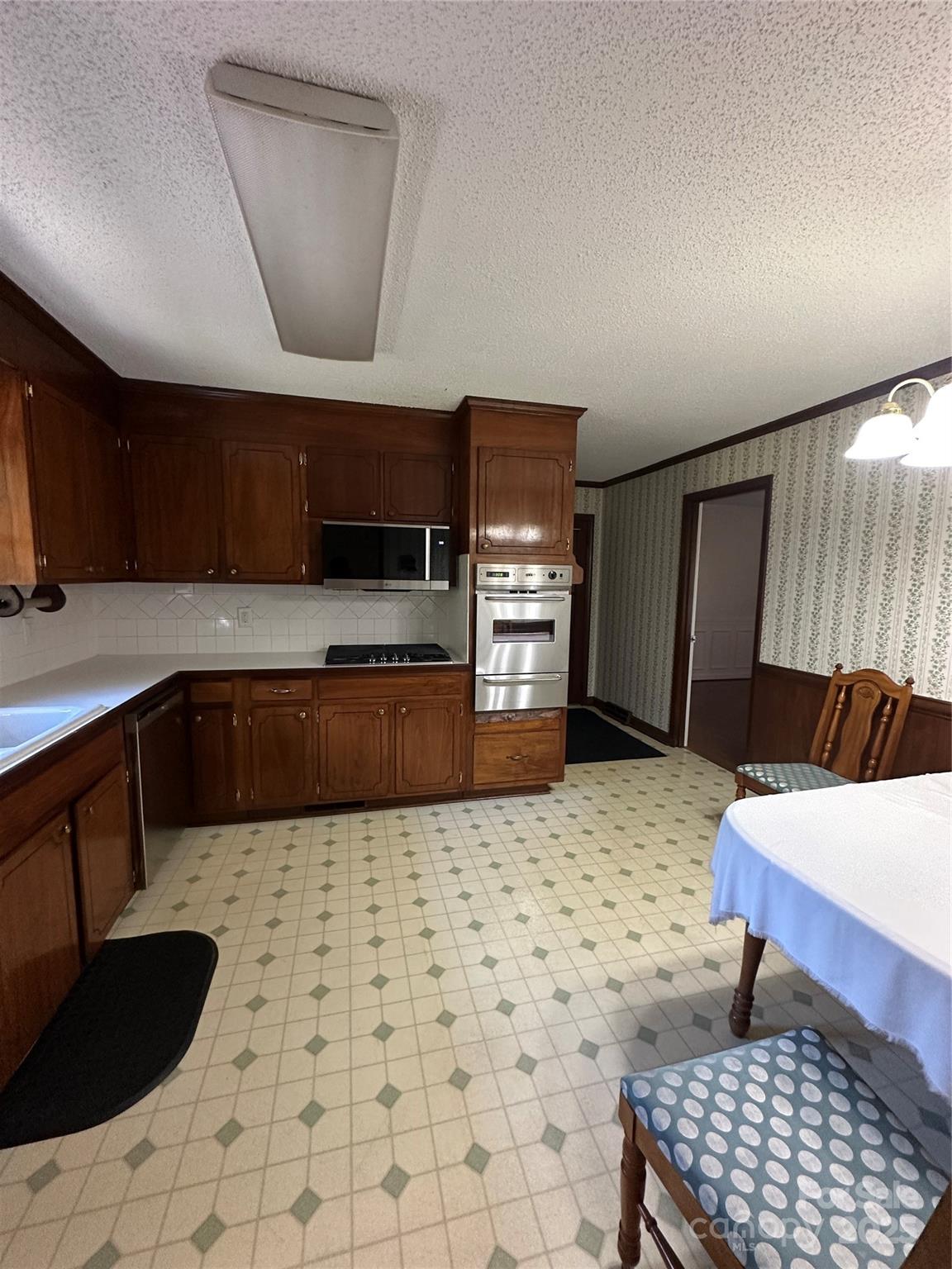 1115 Dumbarton Road Gastonia, NC 28054 - Photo 16 of 20 a kitchen with a sink a stove a refrigerator and cabinets
