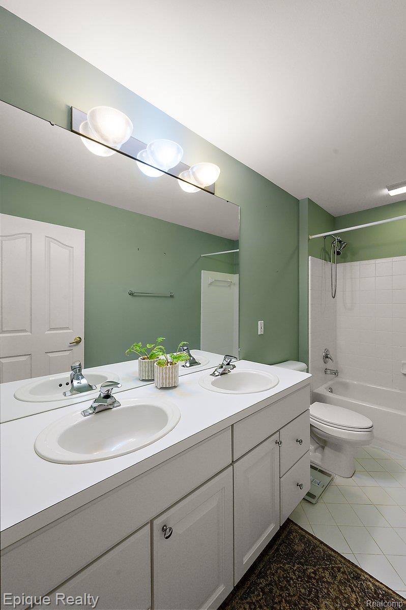 1909 Catlin Drive Rochester, MI 48306 - Photo 36 of 76 Bathroom featuring a dual vanity with integrated sinks, chrome fixtures, and a large wall-mounted mirror