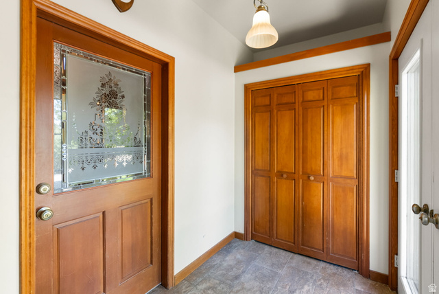 435 Canyon Road Millville, UT 84326 - Photo 7 of 113 Entryway featuring a wood-panel door with decorative frosted glass, bi-fold closet doors, and tile flooring