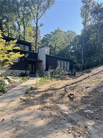 a view of an empty room with window and hardwood floor