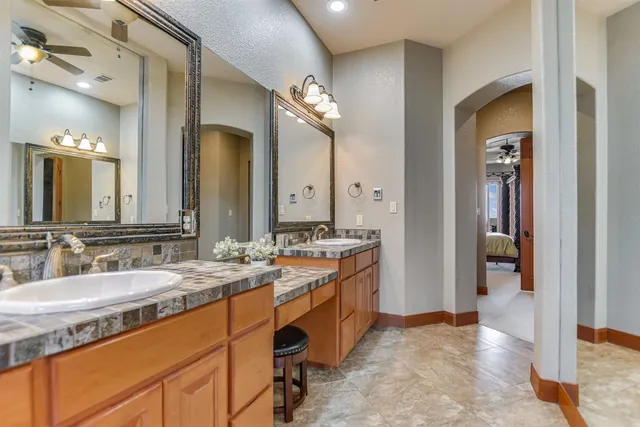 a spacious bathroom with a granite countertop sink and a mirror