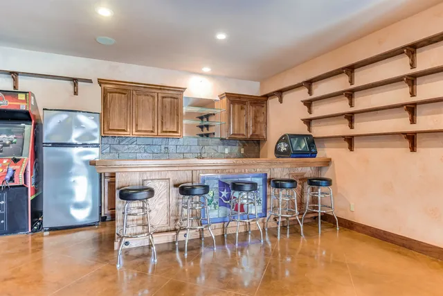 a kitchen with stainless steel appliances granite countertop a stove top oven a sink a dining table and chairs with wooden floor