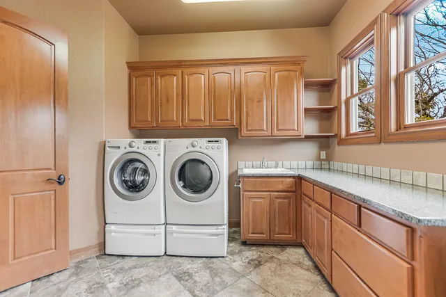 a utility room with sink dryer and washer