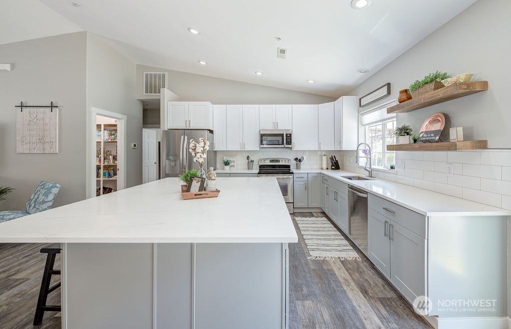 1365 Pitcher Canyon Road Wenatchee, WA 98801 - Photo 8 of 40 a large kitchen with kitchen island a sink a stove a refrigerator and white cabinets with wooden floor