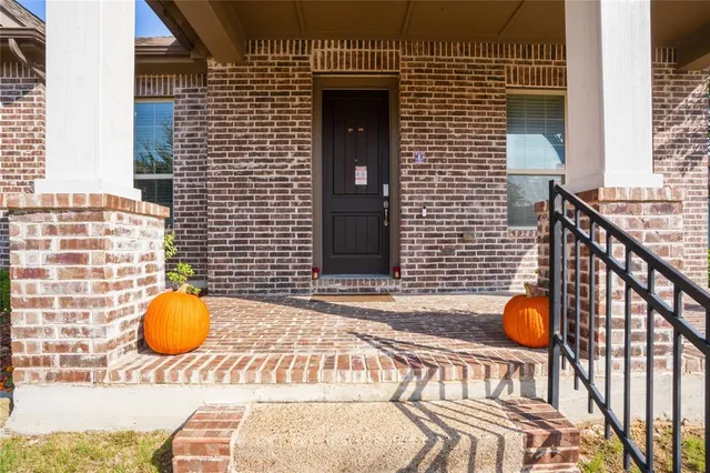 a view of a white house with a small yard and plants