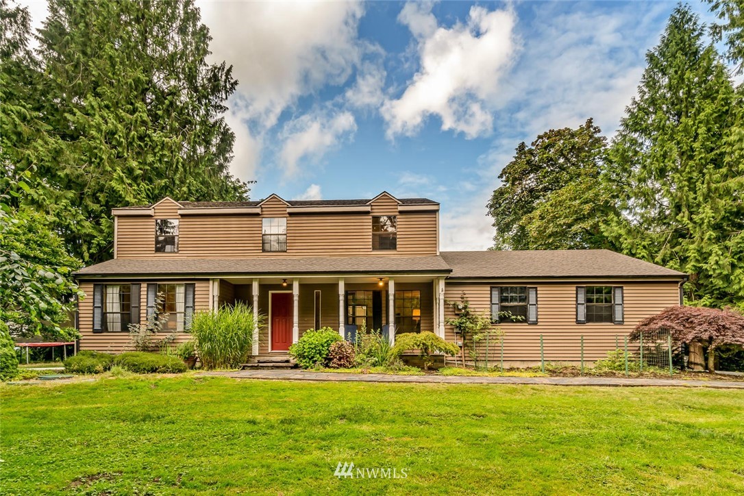 9513 Tveit Road Arlington, WA 98223 - Photo 1 of 40 a front view of a house with a yard table and chairs
