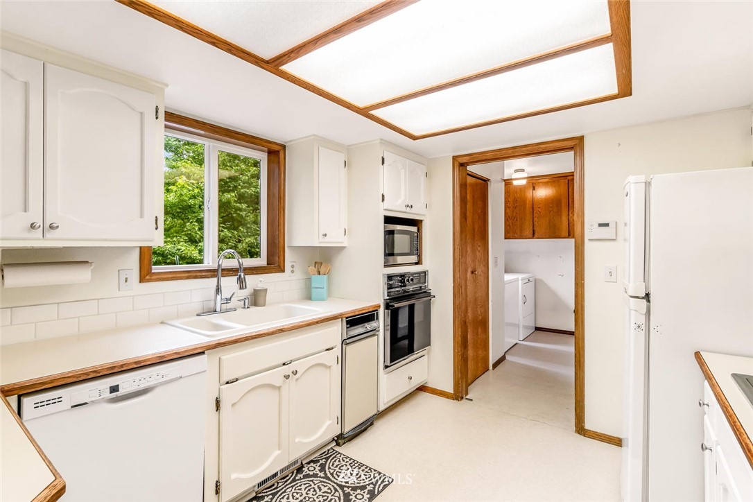 9513 Tveit Road Arlington, WA 98223 - Photo 11 of 40 a kitchen with white cabinets and window