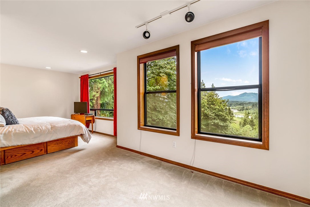 9513 Tveit Road Arlington, WA 98223 - Photo 21 of 40 a spacious bedroom with a large bed and a window