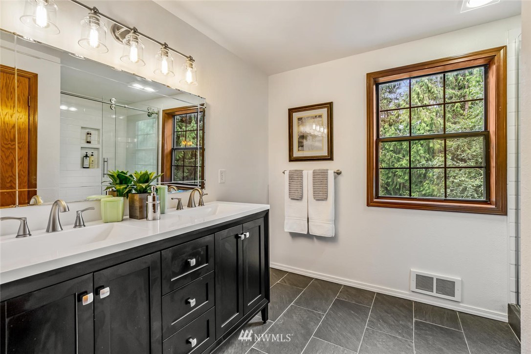 9513 Tveit Road Arlington, WA 98223 - Photo 23 of 40 a bathroom with a granite countertop sink a large mirror and a window