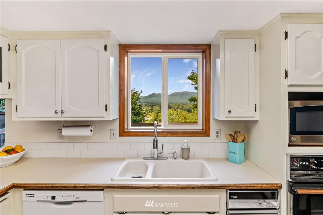 9513 Tveit Road Arlington, WA 98223 - Photo 10 of 40 a kitchen with stainless steel appliances white cabinets and a sink