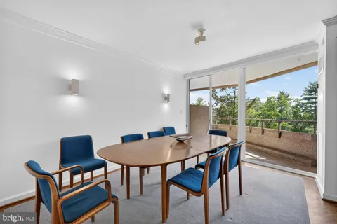 a dining room with furniture a rug and a floor to ceiling window