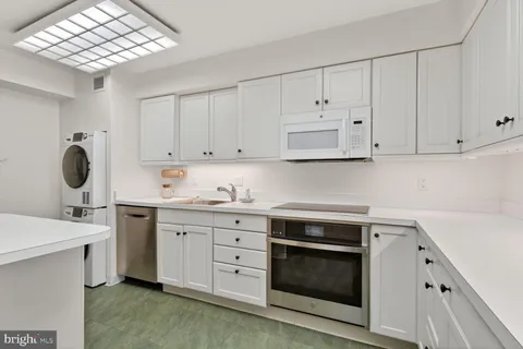 a kitchen with cabinets appliances a sink and a counter top space
