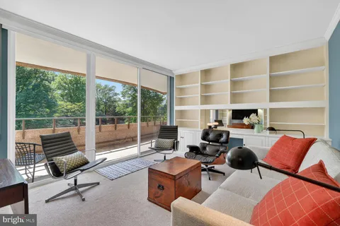 a living room with furniture and a floor to ceiling window