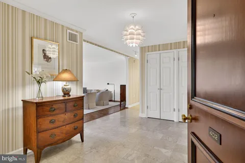 a view of hall way with furniture and chandelier