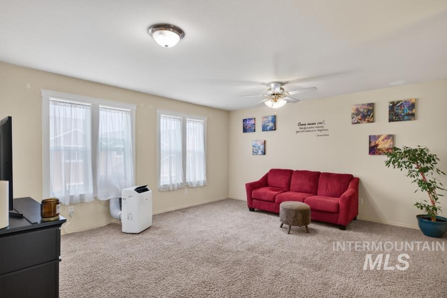 1337 Bristol Road Moscow, ID 83843 - Photo 4 of 28 Spacious room featuring carpeting, multiple windows providing natural light, a ceiling fan with integrated lighting, and a flush-mount ceiling light