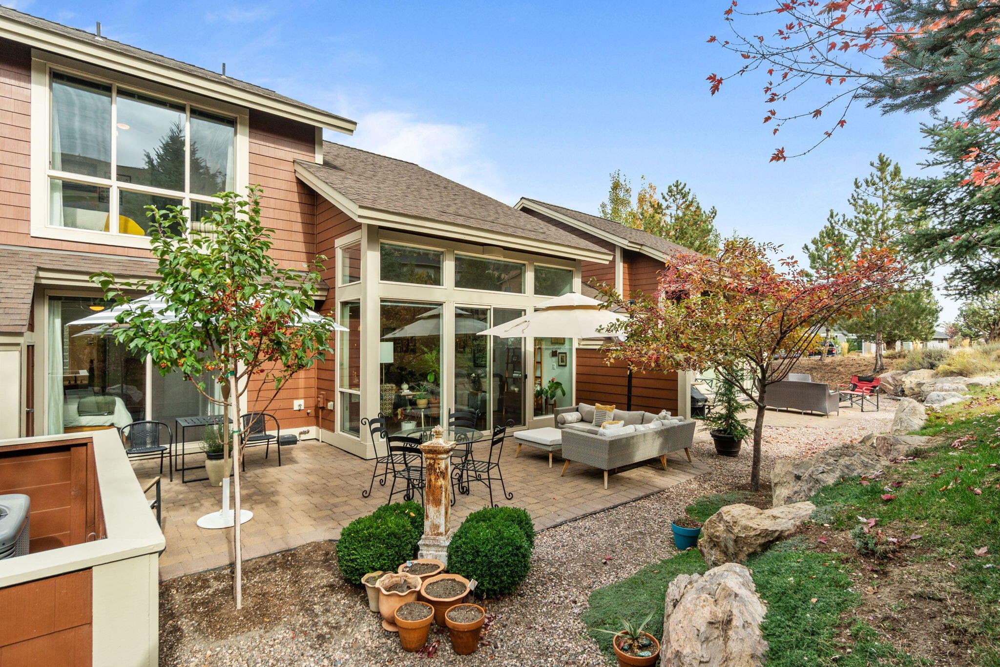 10942 Village Loop Redmond, OR 97756 - Photo 8 of 45 a view of a patio with couches table and chairs potted plants and a large tree