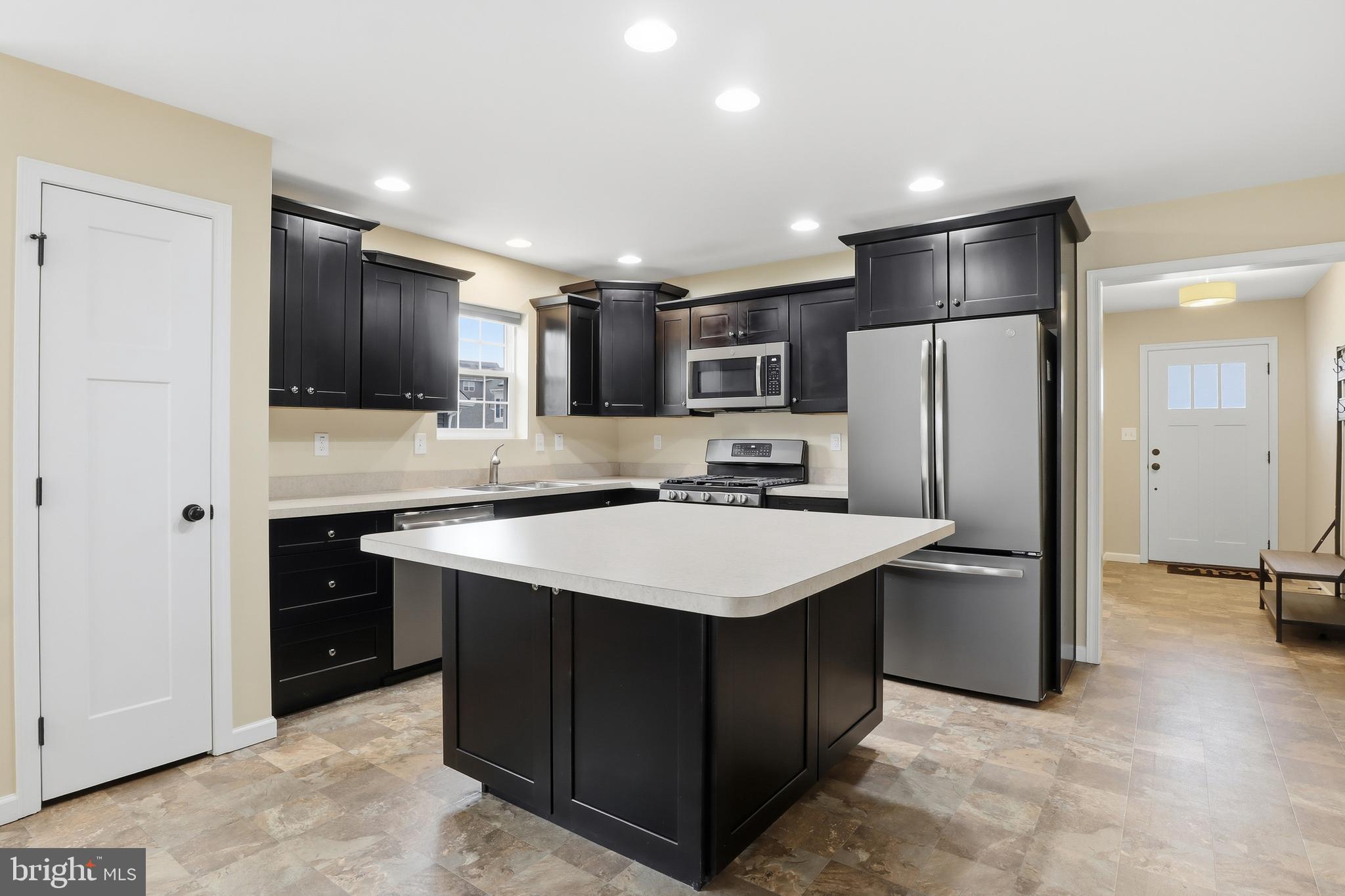 2606 Woodspring Drive York, PA 17402 - Photo 11 of 60 a kitchen with stainless steel appliances a refrigerator a sink a stove a microwave and island