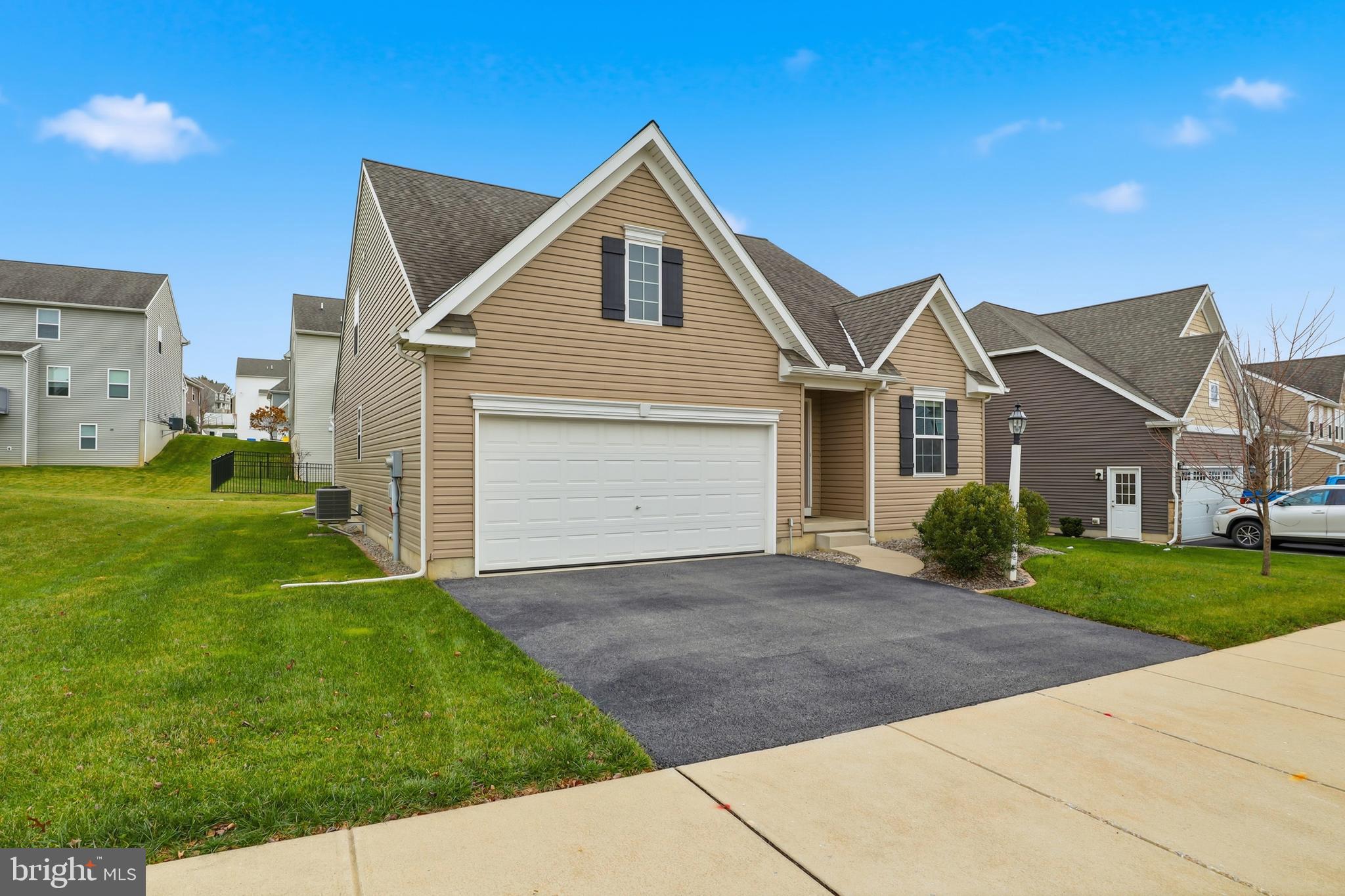 2606 Woodspring Drive York, PA 17402 - Photo 2 of 60 a front view of a house with a yard and garage