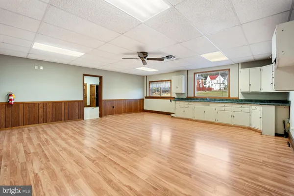a large kitchen with stainless steel appliances granite countertop a sink dishwasher and a fireplace with wooden floor