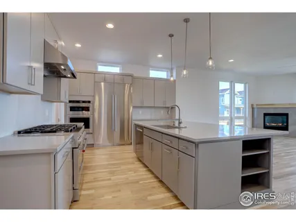 a kitchen with stainless steel appliances granite countertop a sink a stove and a refrigerator