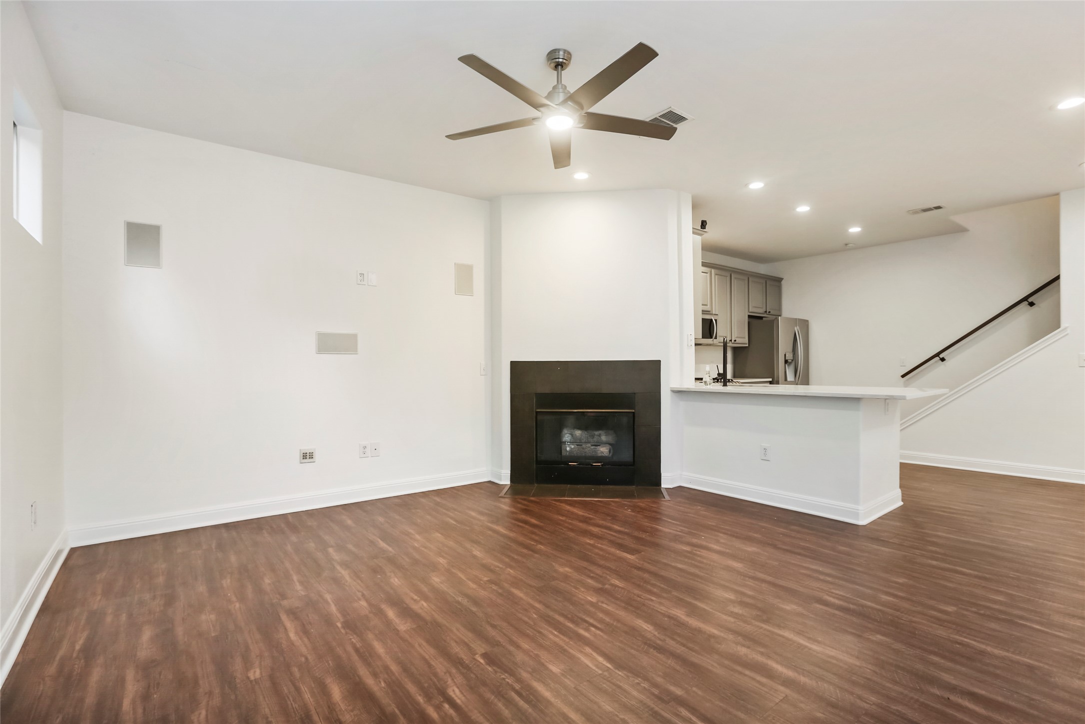 3406 Menchaca Road, Unit 19 Austin, TX 78704 - Photo 6 of 25 Rich wood-look flooring and a modern corner fireplace anchor this open-concept main level.