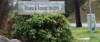 a sign broad in front of a tree