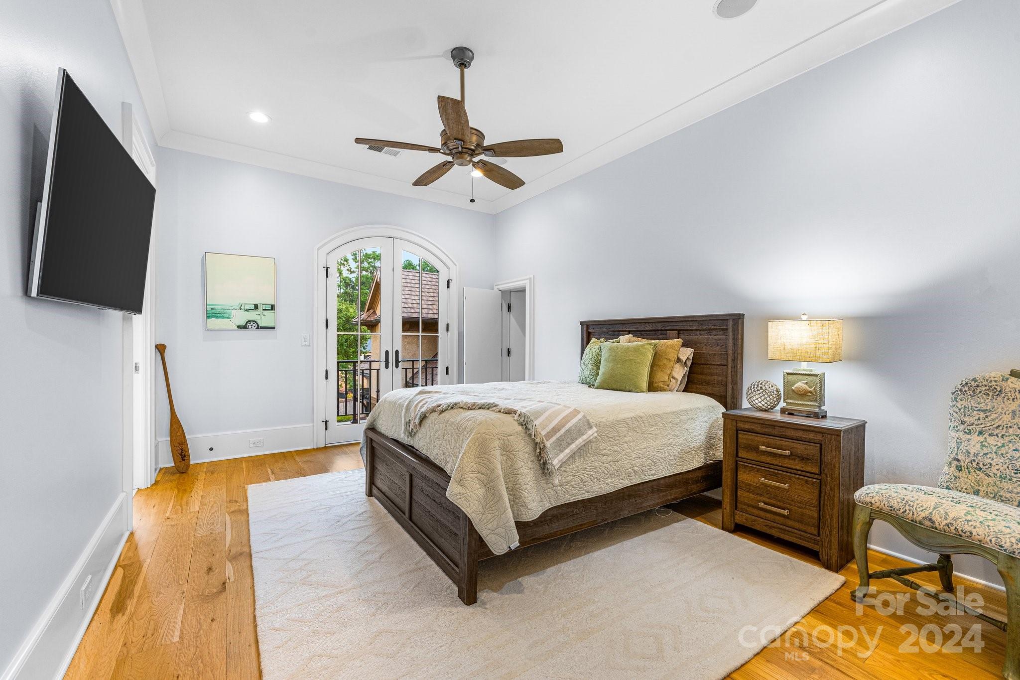 16700 Tinker Place Cornelius, NC 28031 - Photo 27 of 47 a spacious bedroom with a bed a flat screen tv and a chandelier