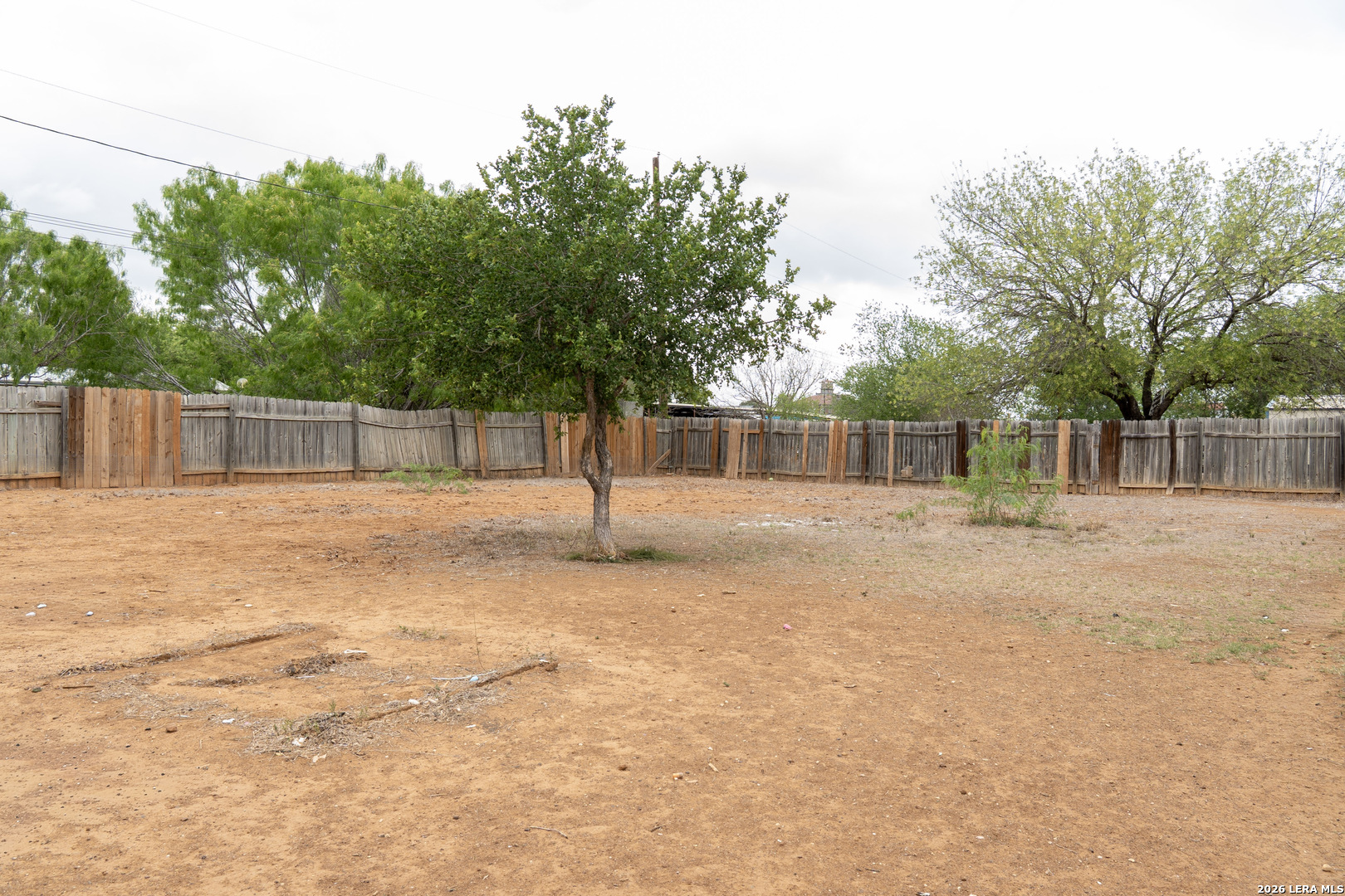 507 Beech Street Jourdanton, TX 78026 - Photo 16 of 17 a backyard of a house with large trees and outdoor seating