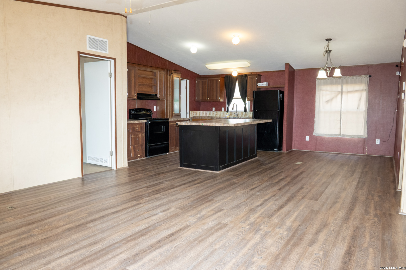 507 Beech Street Jourdanton, TX 78026 - Photo 3 of 17 a kitchen with stainless steel appliances kitchen island granite countertop a refrigerator a stove top oven a sink with island and chairs
