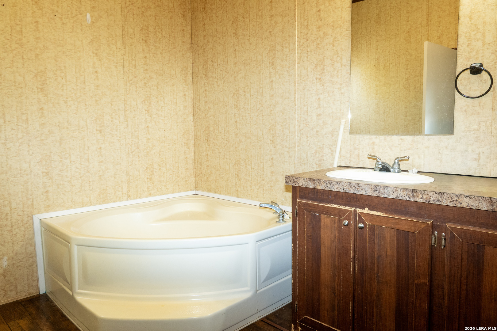 507 Beech Street Jourdanton, TX 78026 - Photo 8 of 17 a bathroom with a granite countertop sink and a bathtub