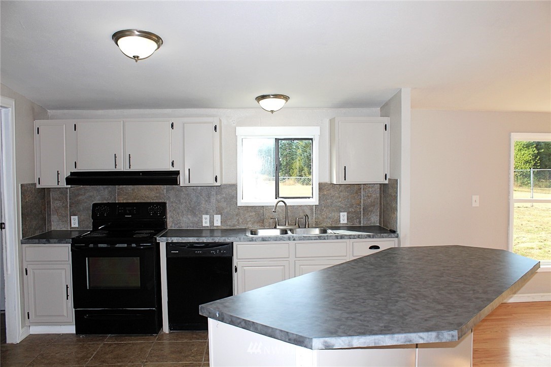 18445 Forstrom Street Southwest Rochester, WA 98579 - Photo 6 of 14 a kitchen with stainless steel appliances granite countertop a sink a stove and a refrigerator