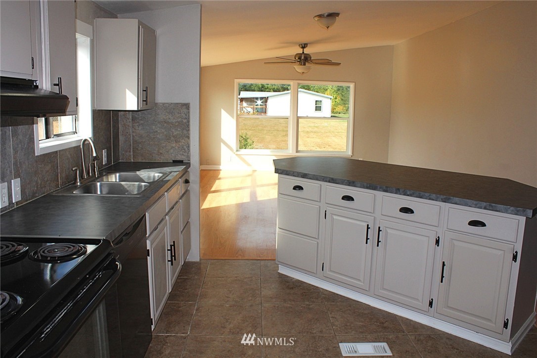 18445 Forstrom Street Southwest Rochester, WA 98579 - Photo 7 of 14 a kitchen with granite countertop a sink a stove and cabinets
