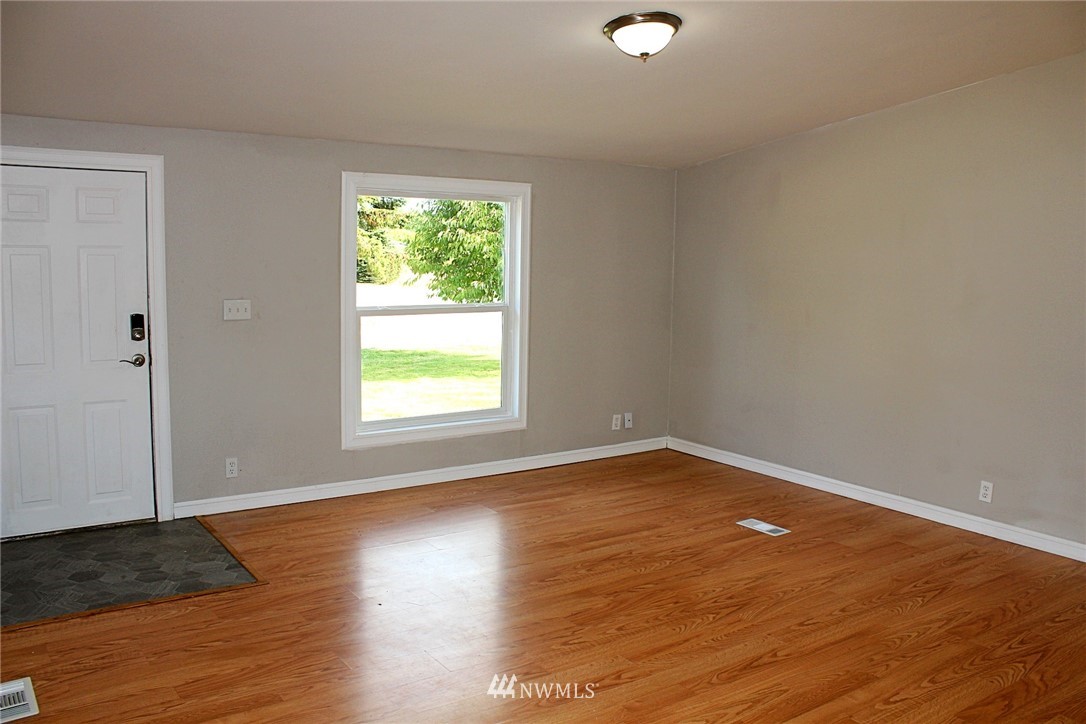 18445 Forstrom Street Southwest Rochester, WA 98579 - Photo 9 of 14 an empty room with wooden floor and windows