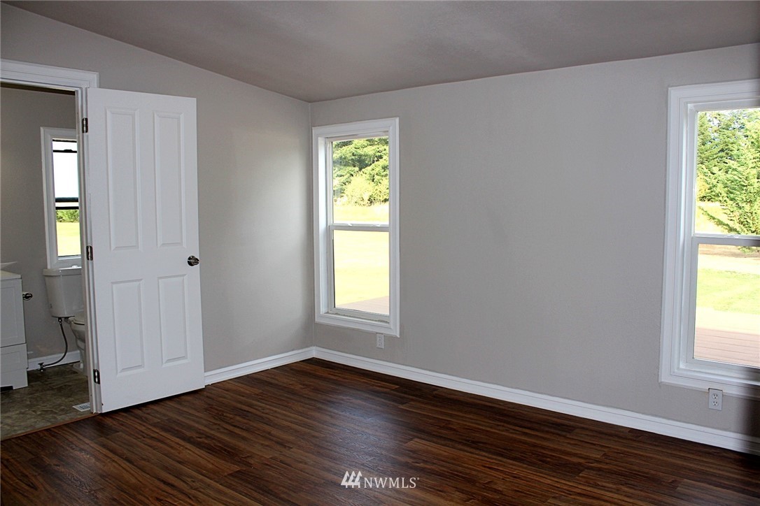 18445 Forstrom Street Southwest Rochester, WA 98579 - Photo 10 of 14 a view of an empty room with wooden floor and a window