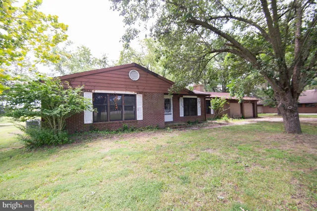 a backyard of a house with yard table and chairs