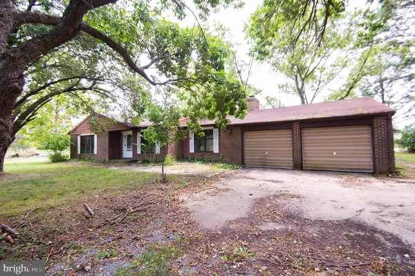 a wooden house with a big yard and large trees