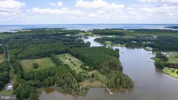 an aerial view of residential houses with outdoor space and lake view