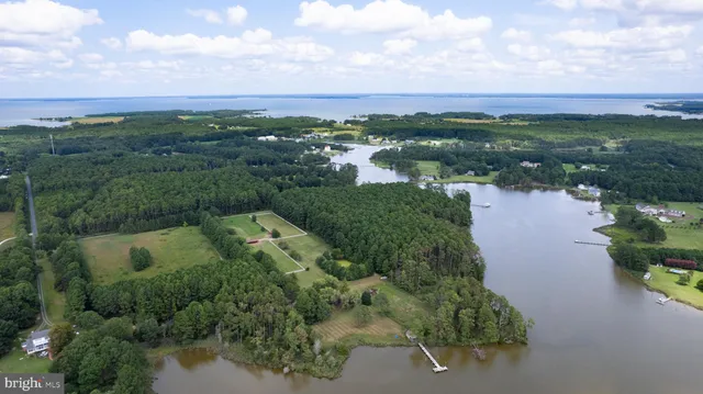 an aerial view of residential houses with outdoor space and lake view