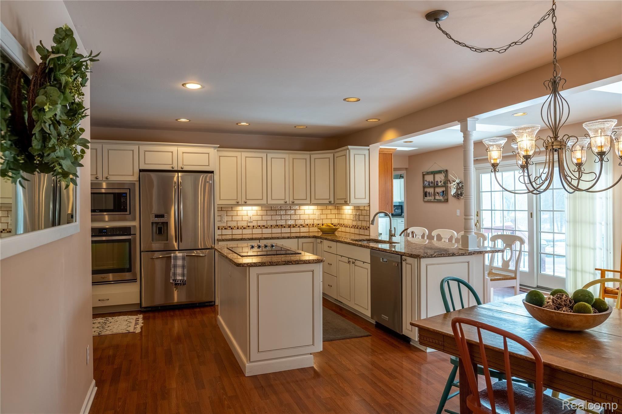 Kitchen features custom cabinets, stainless steel appliances and a cozy eat-in area